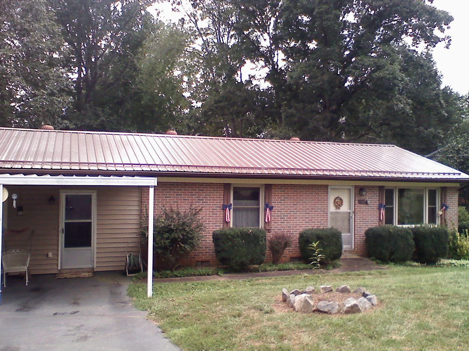 Bronze metal roof and carport on a brick ranch home — Roof Repair work by our crew in Keyport